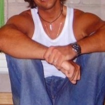 Pedro Enrique sonriente sentado en pared